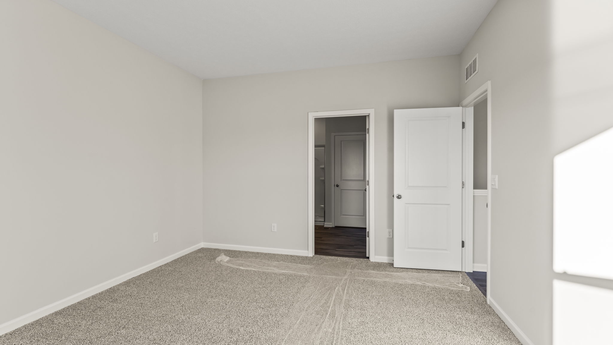 Primary bedroom with door to primary bathroom.