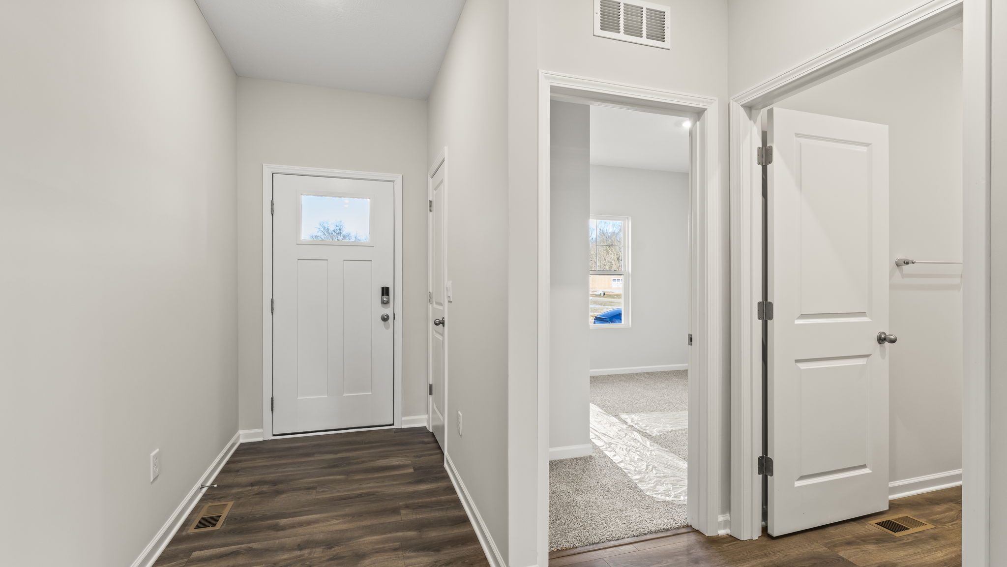 Front of the home with door on the left and bedroom on the right.