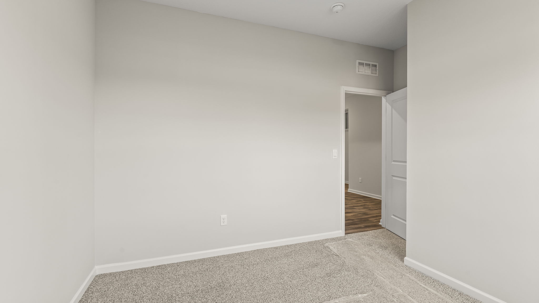 Carpeted bedroom with door to hallway