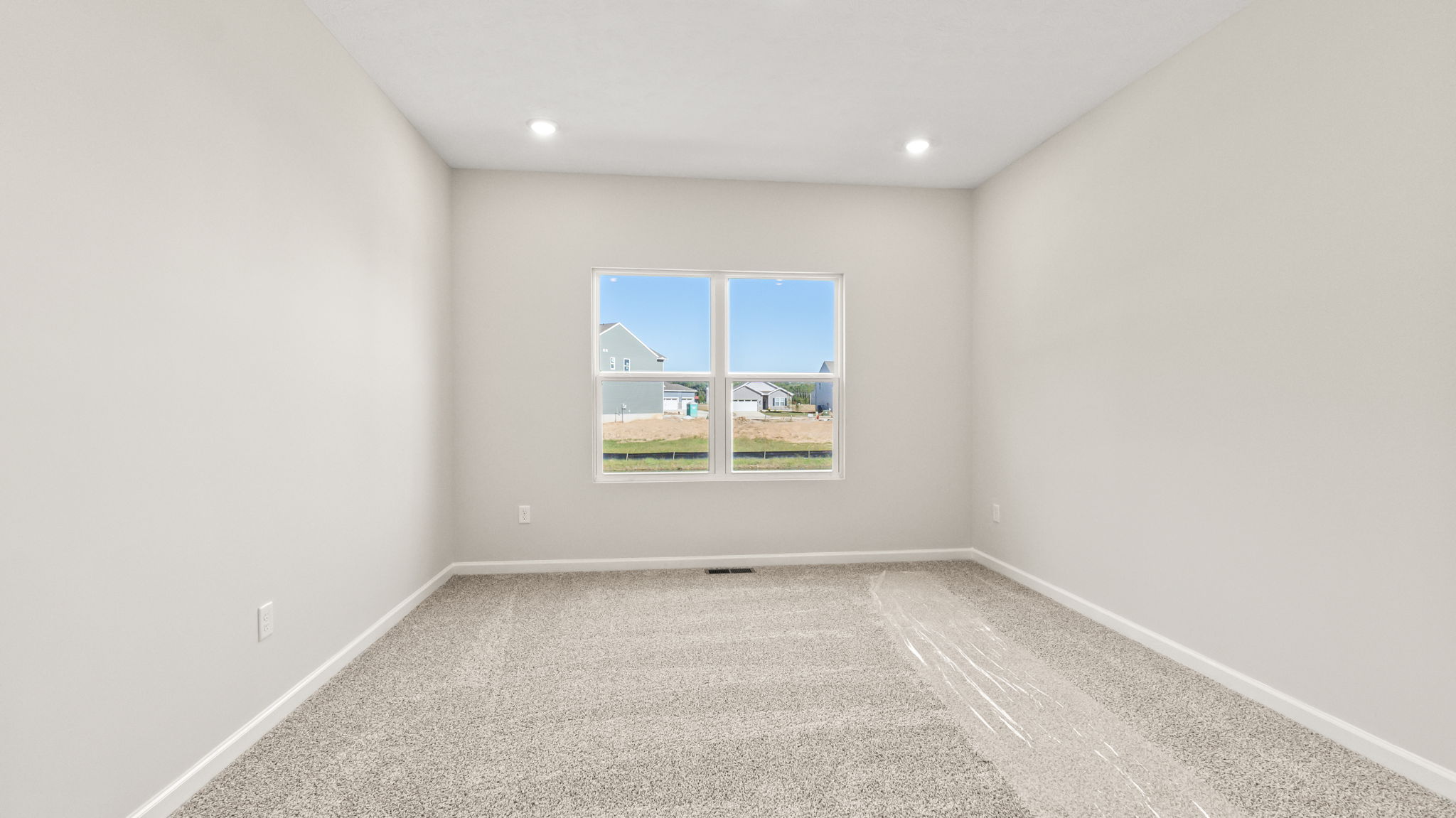 carpeted primary bedroom with window