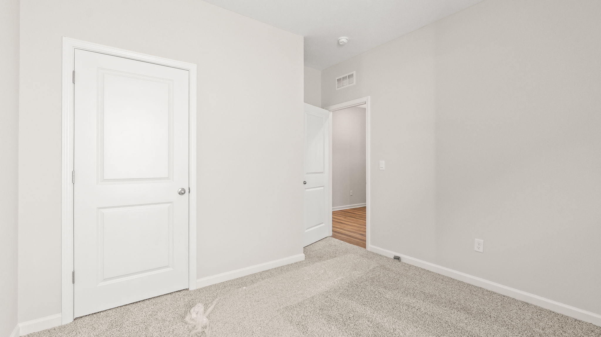 carpeted bedroom with door to  hallway