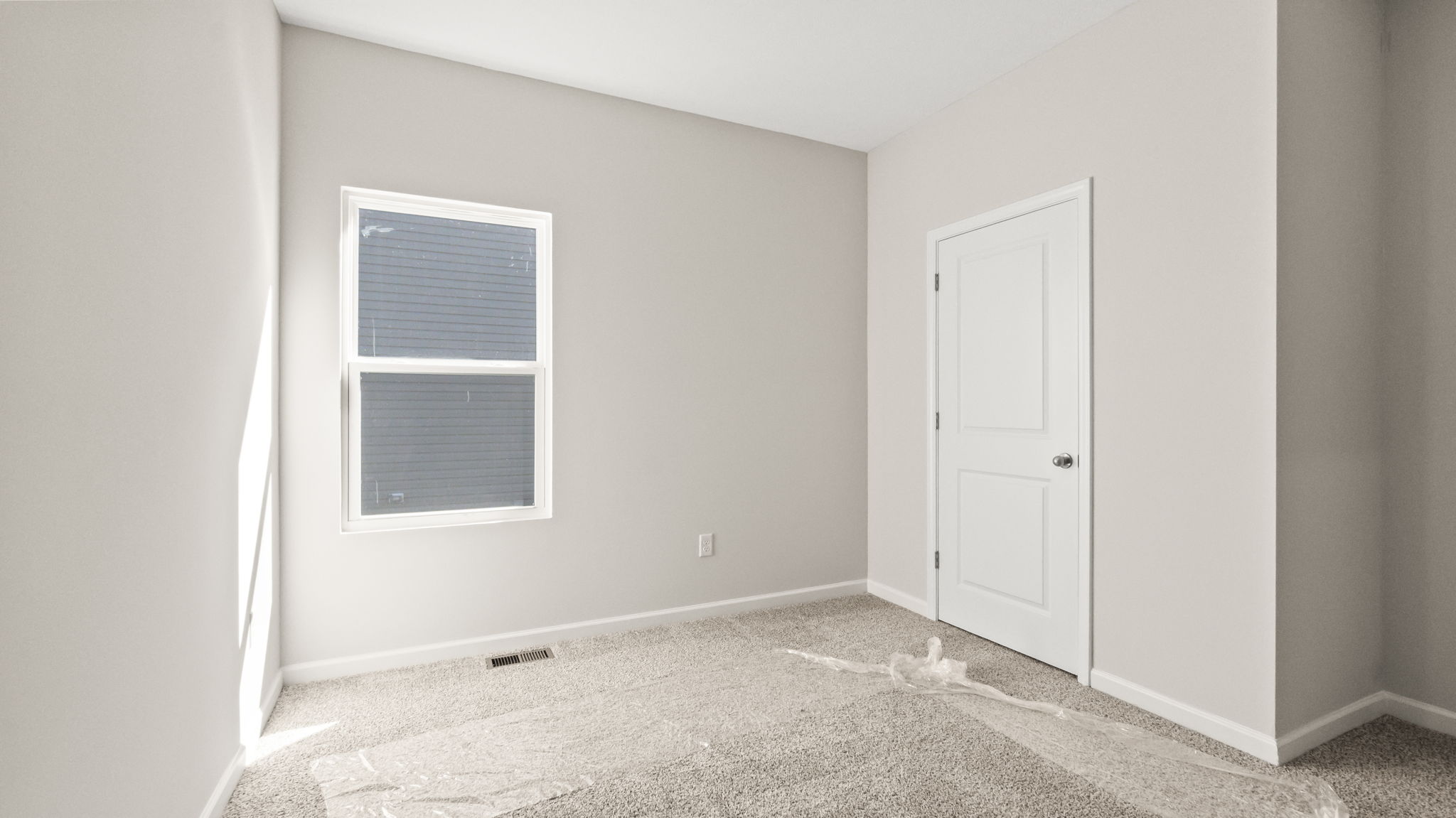 Carpeted bedroom with window and closet door