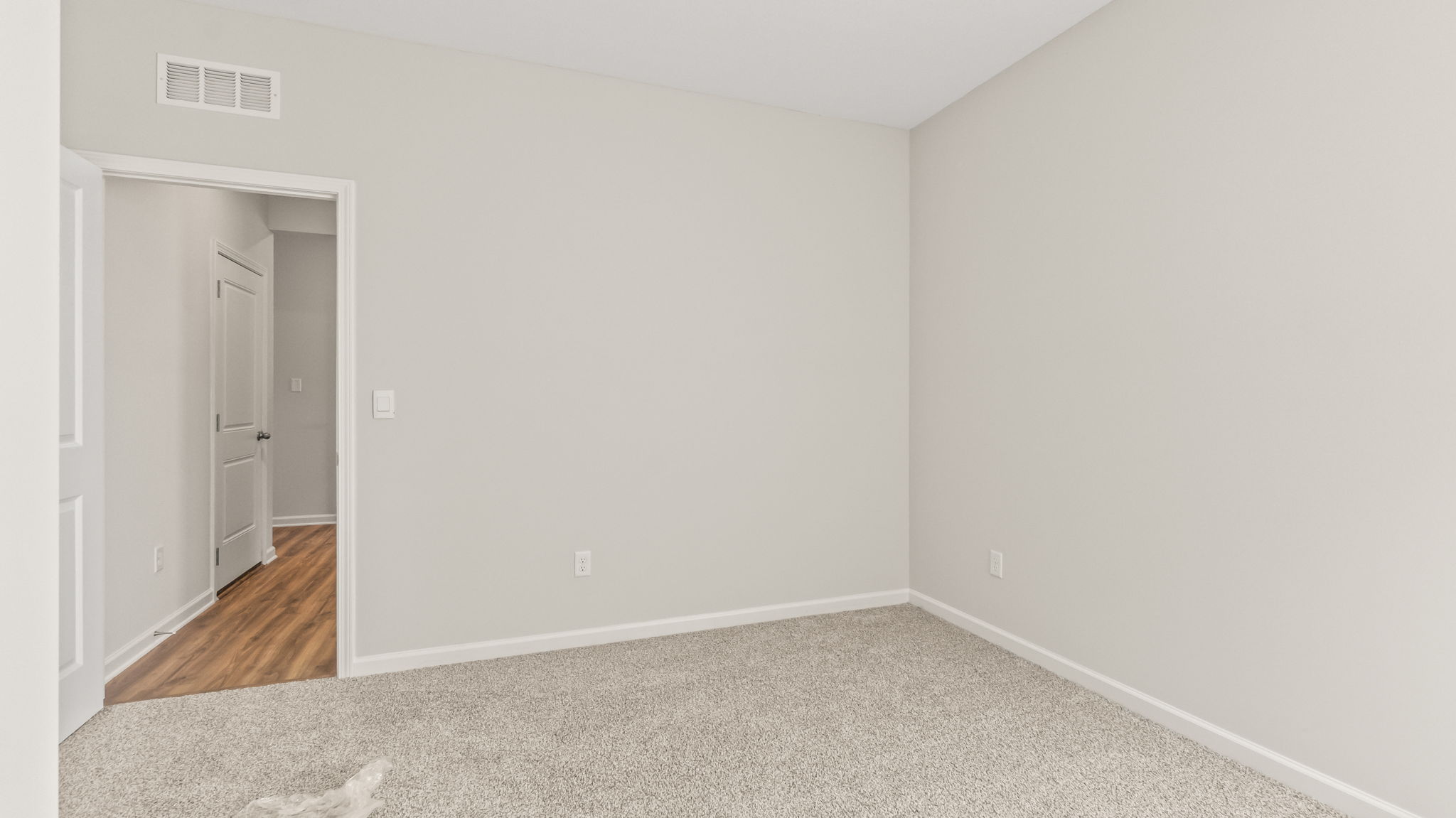 Carpeted bedroom with door to hallway