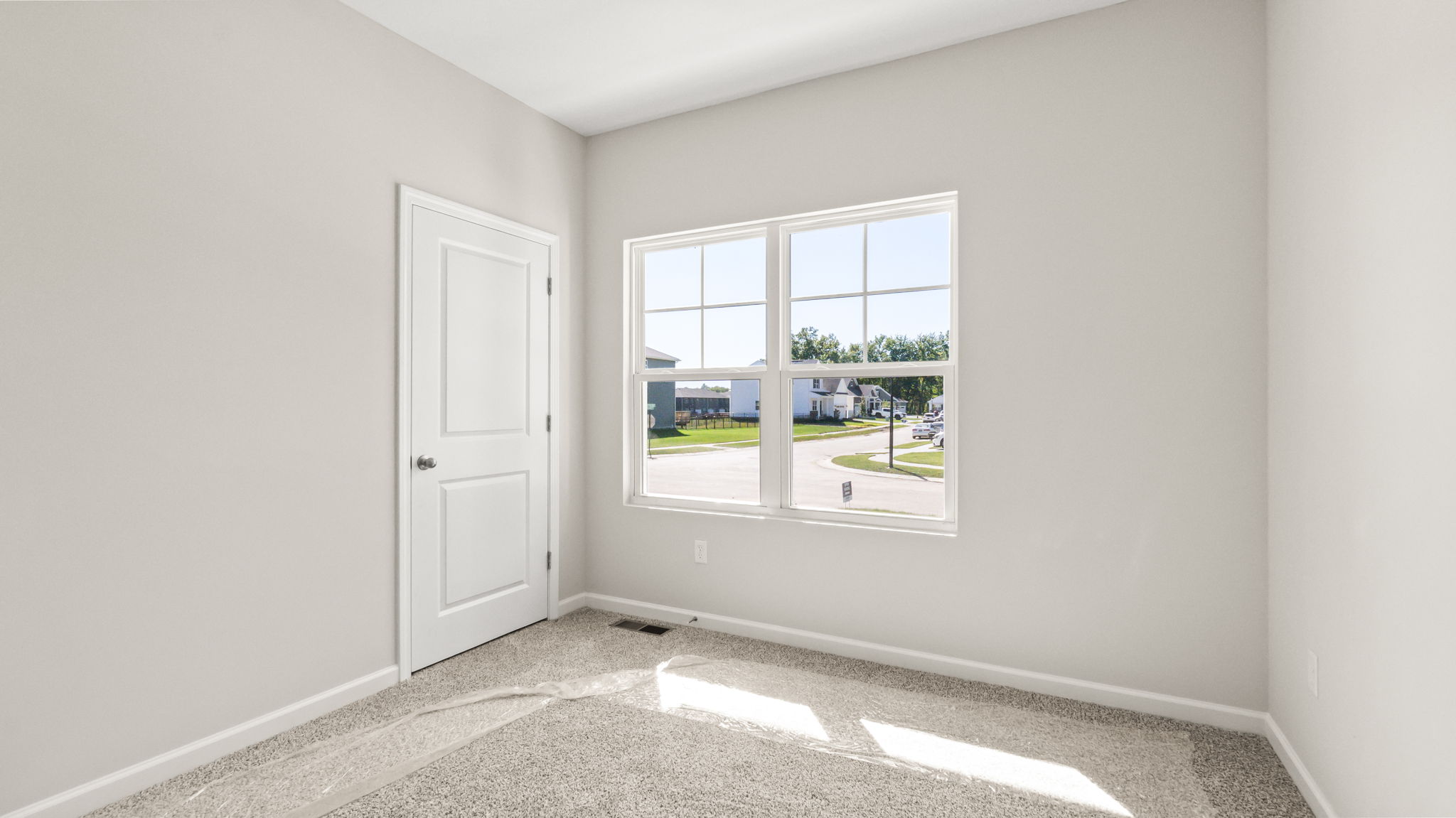 carpeted bedroom with window and closet door