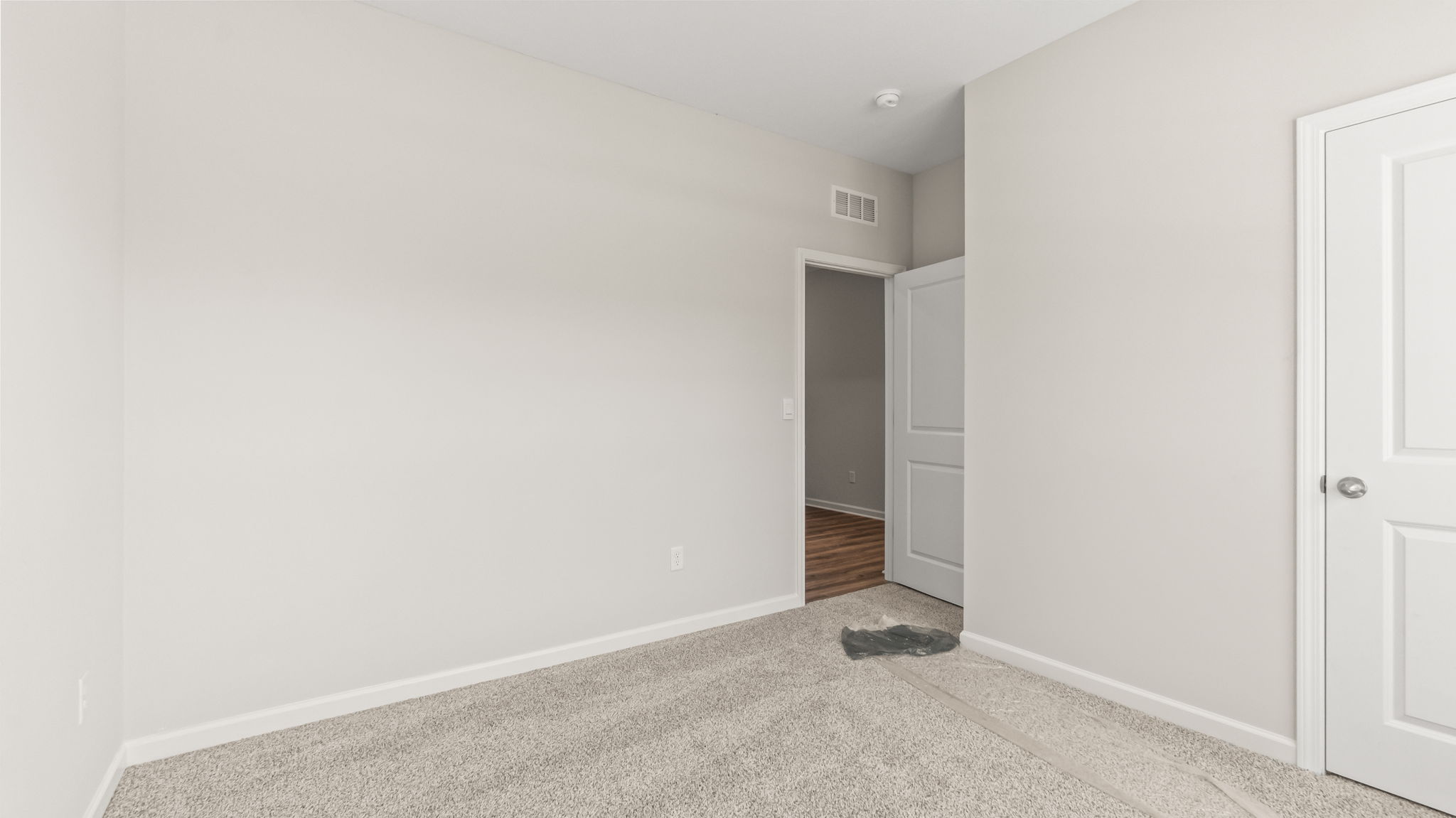 carpeted bedroom with window and closet door