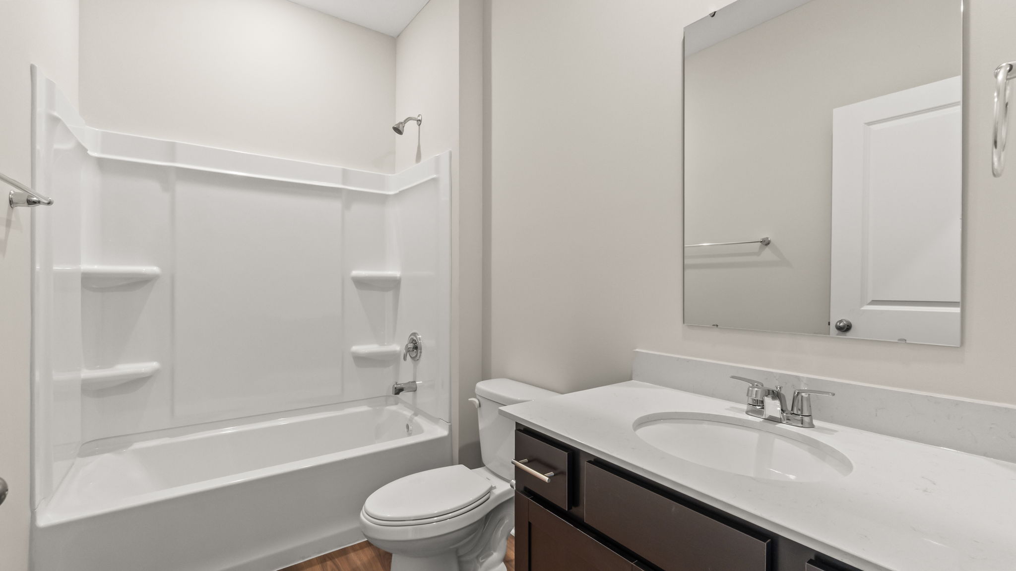 closeup of bathroom sink with toilet and tub with tiered shelving in the background