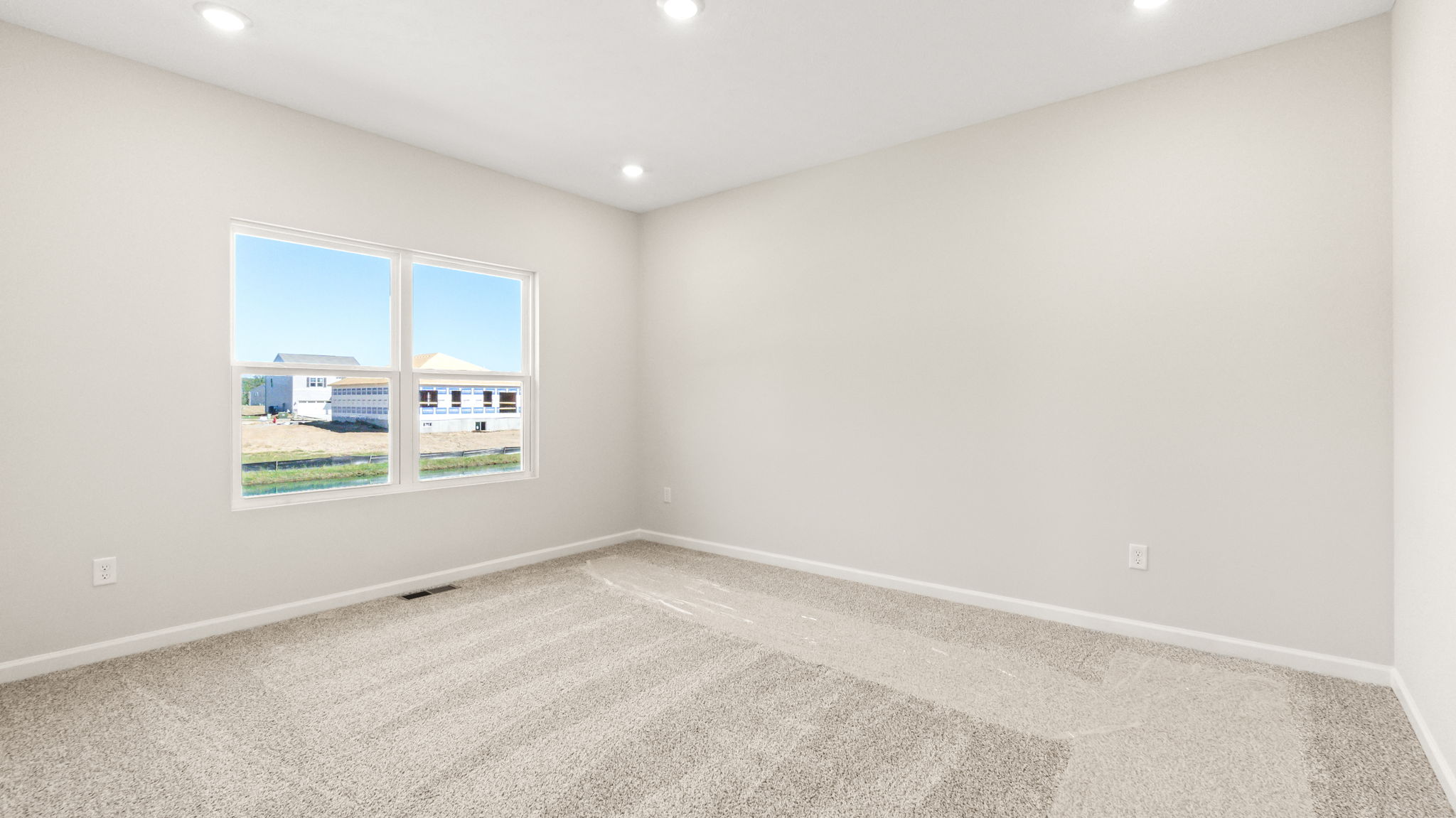 carpeted primary bedroom with window