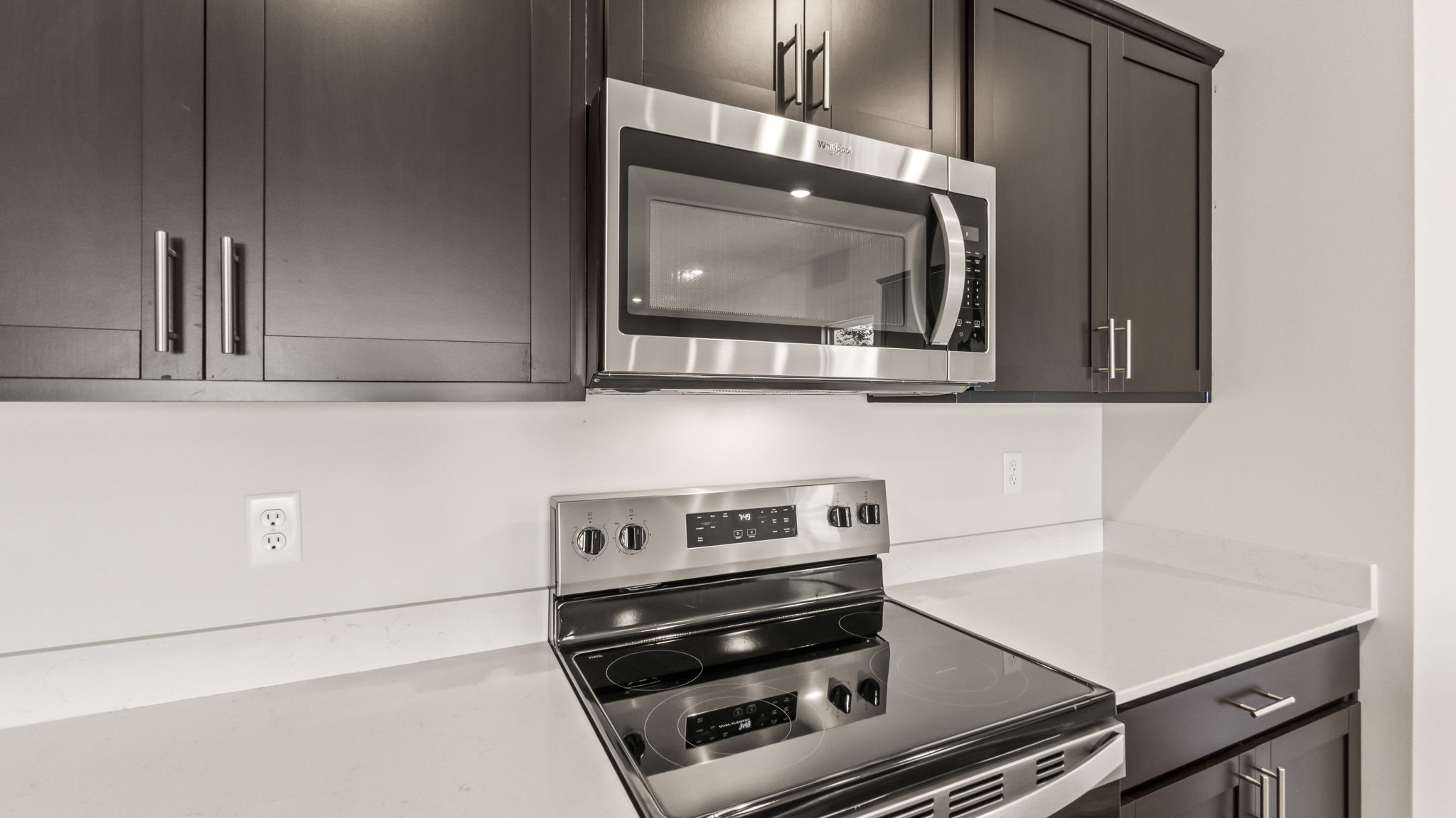 closeup of oven range and microwave inbetween countertops and cabinetry