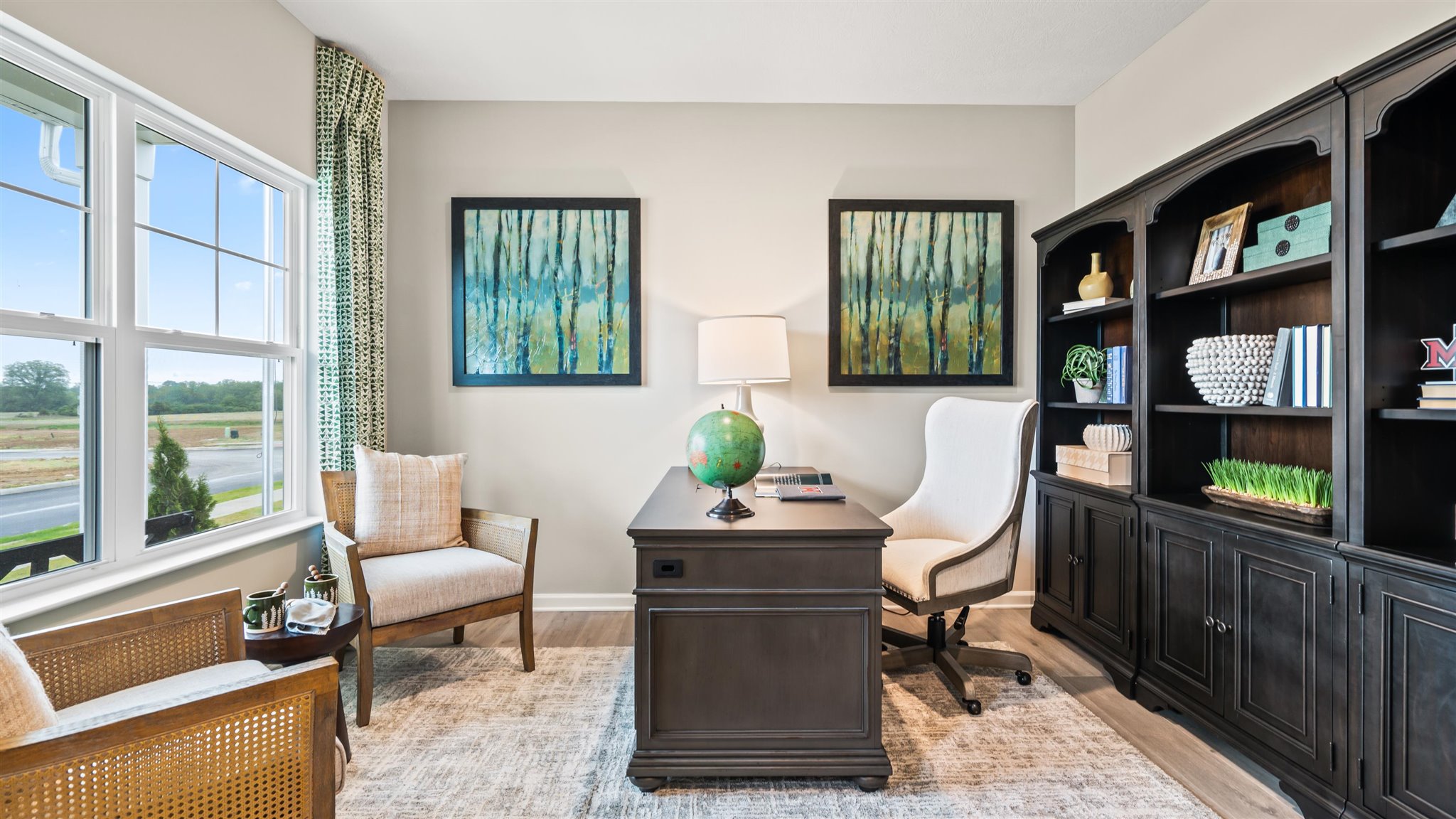 Office in full with large black cabinets and modern art.