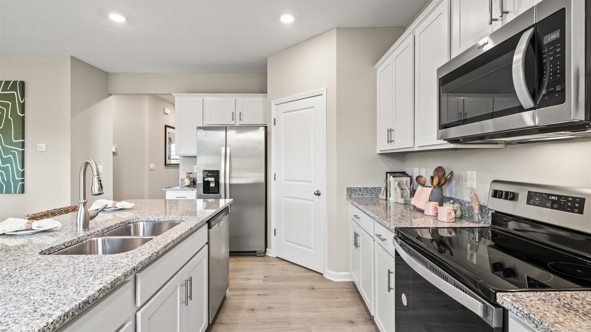 Shotgun view of kitchen with tons of countertop space and stainless steel appliances.