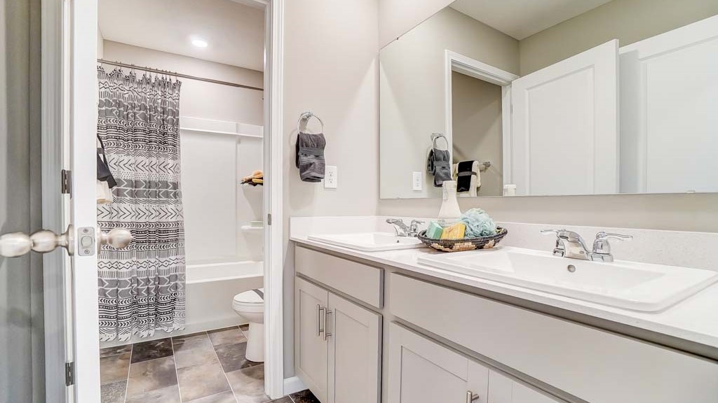 Shared bathroom with dual vanity sinks.