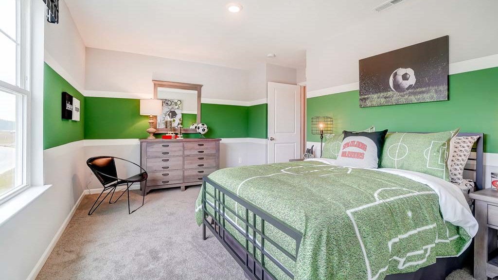 Bedroom with soccer theme and wooden furniture.