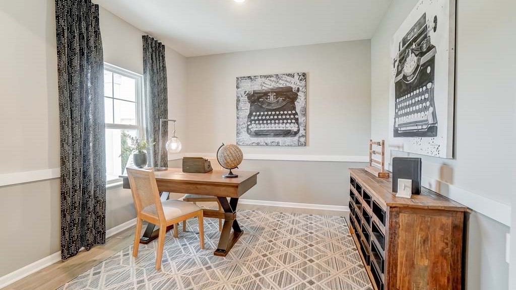 foyer with modern decorations leading into great room and office.