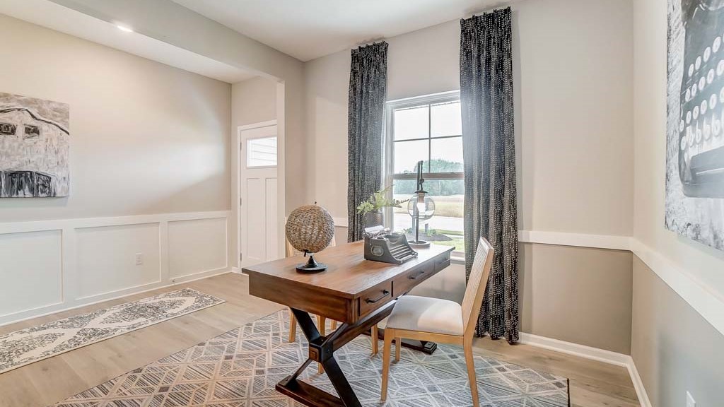 office with modern decorations and wooden desk and view of front door.