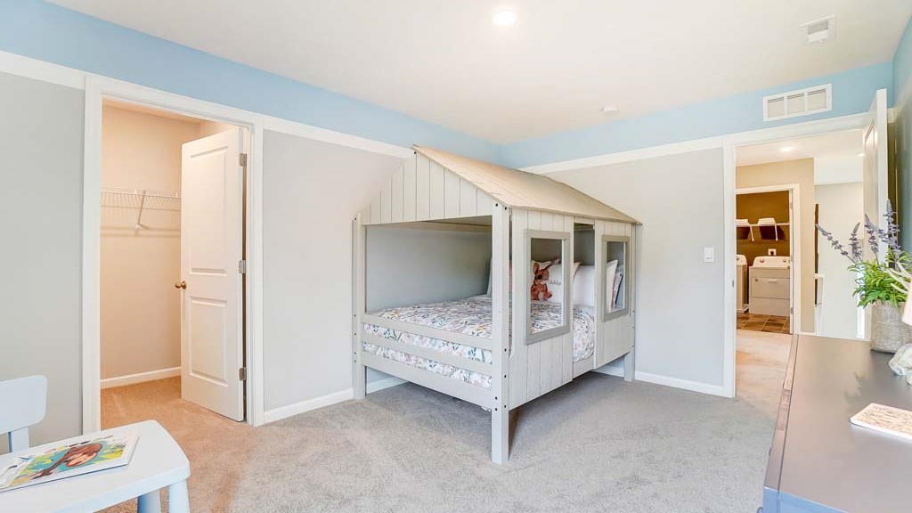 bedroom with house shaped bed and view into the closet.