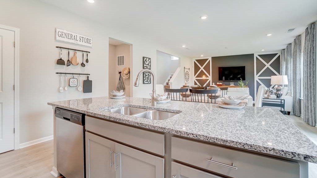 Kitchen island with dual sinks and large great room in background.