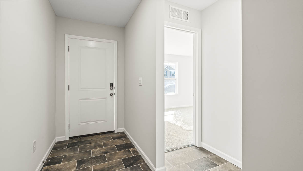 Hallway looking at front door and another bedroom