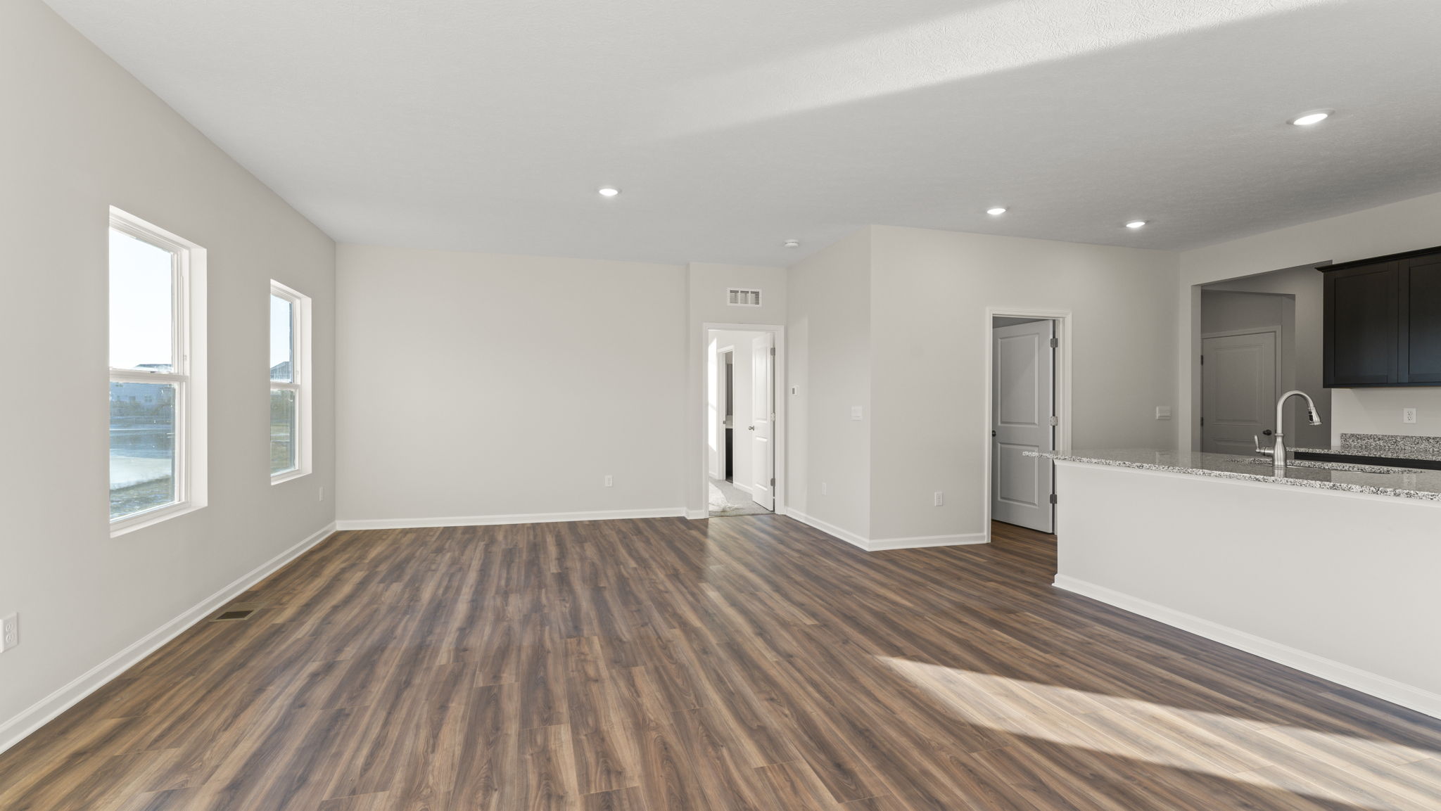 Side view of great room headed into primary bedroom