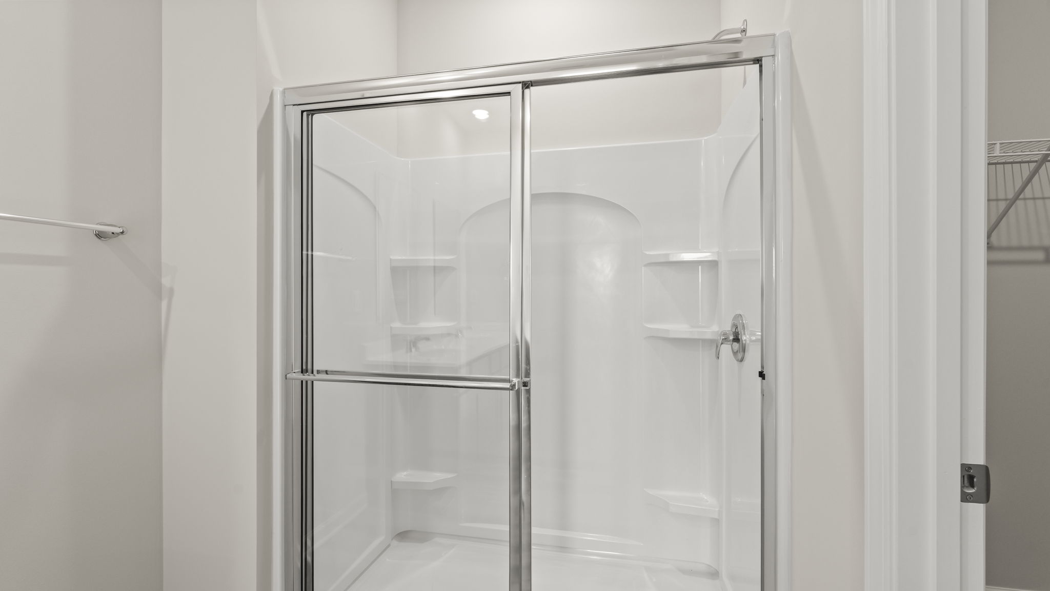 Closeup of wlak-in shower with tiered shelving.