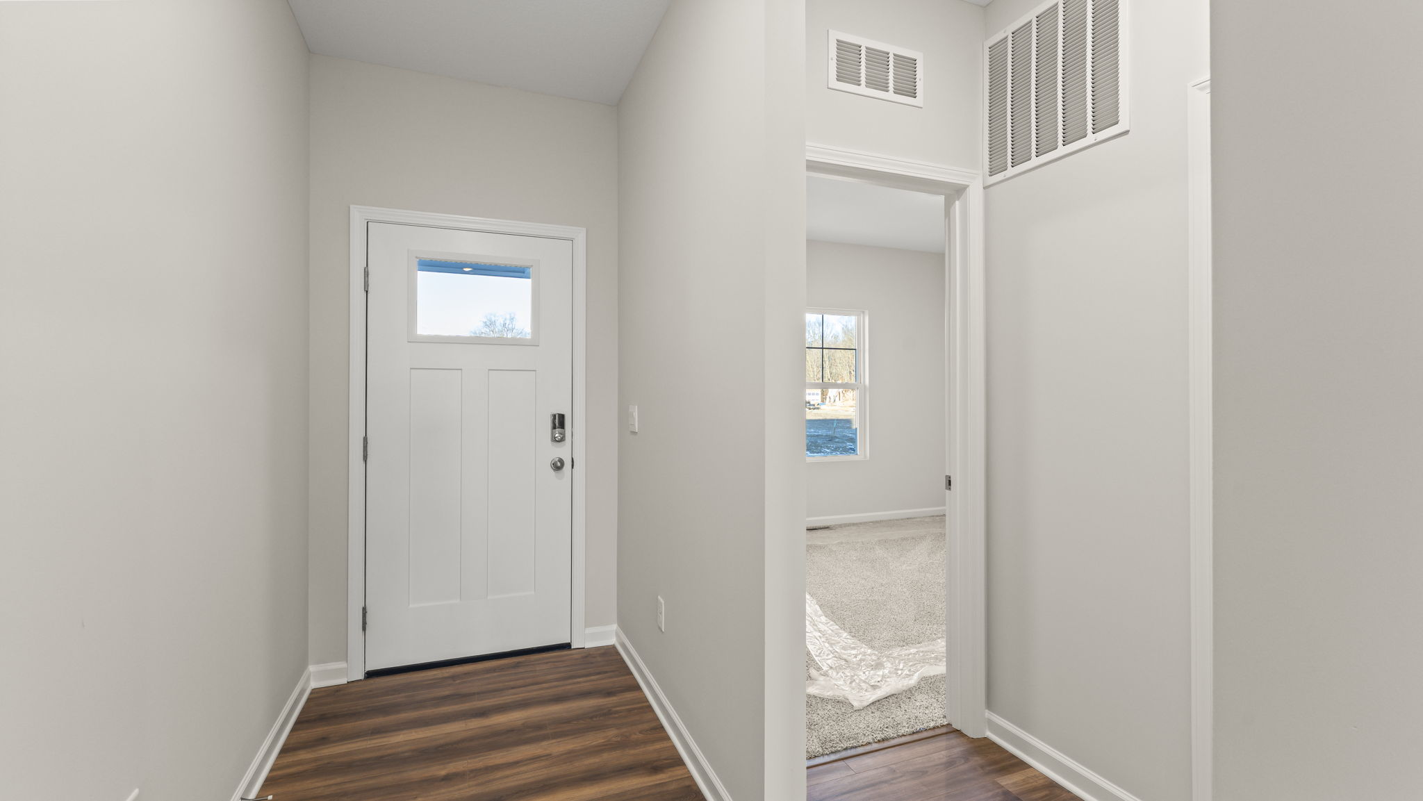 Front door of the home with bedroom next to it