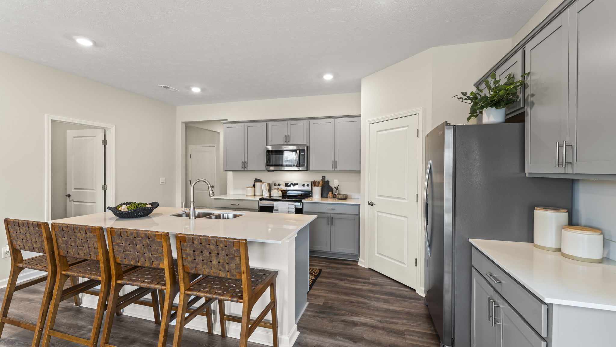 View of the kitchen from the right of the island with quartz countertops, cabinets, and island.