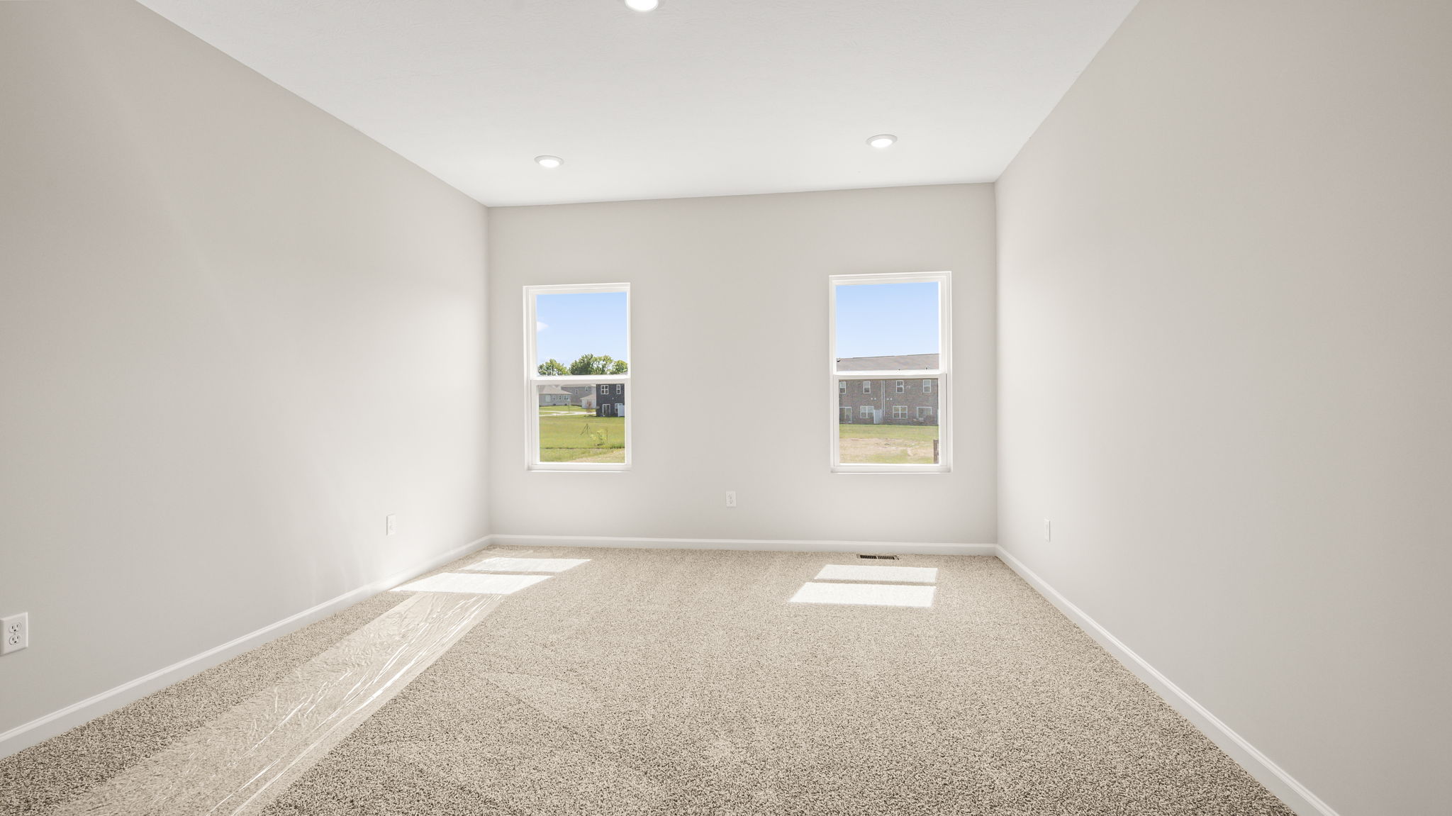 Carpeted primary bedroom with two windows