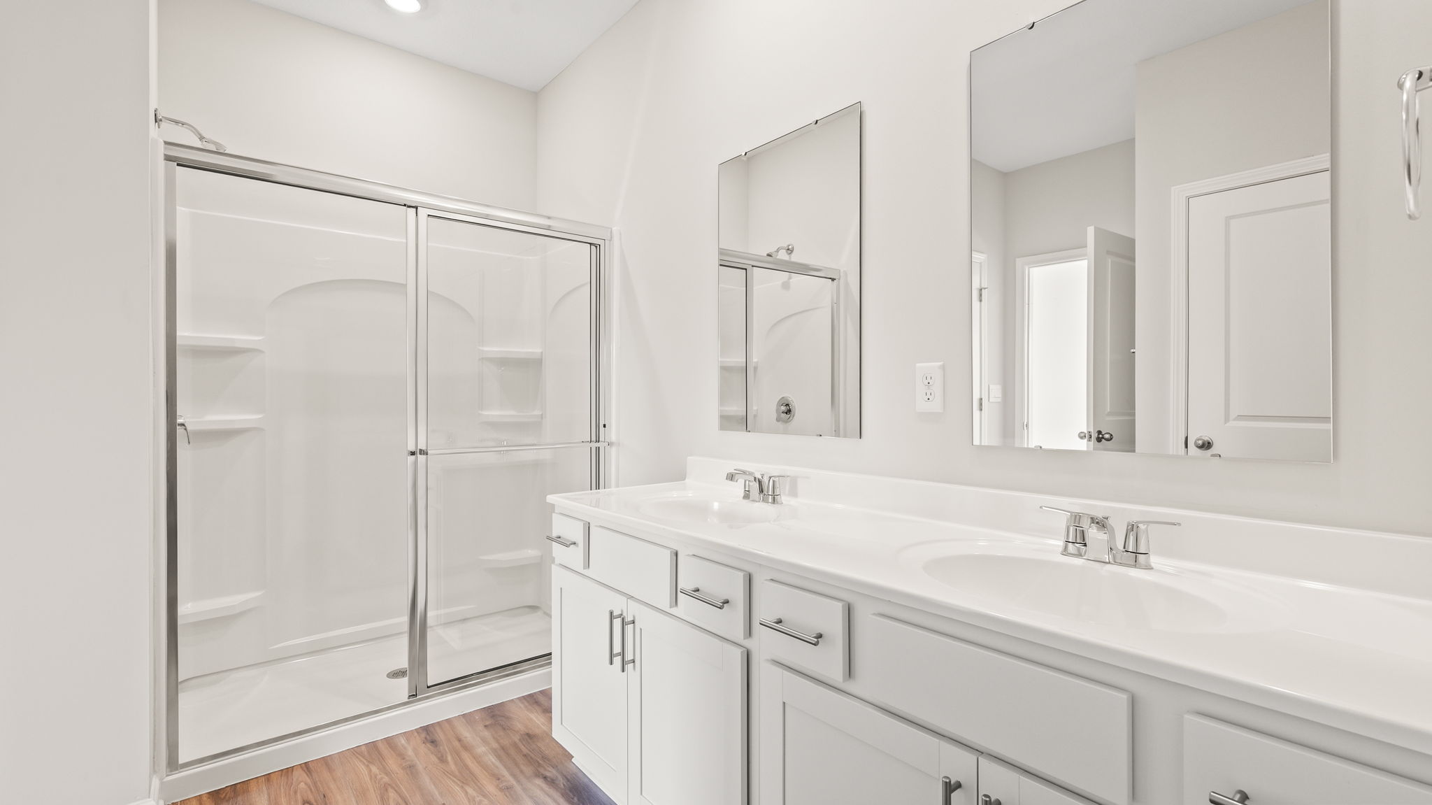 Primary bathroom with dual sink vanity and glass shower