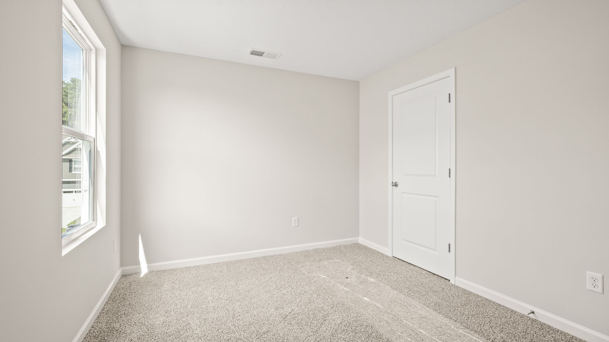 Carpeted bedroom with window and closet door