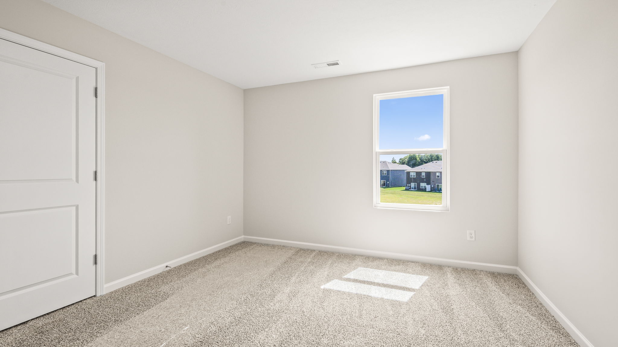 Carpeted bedroom with window and closet door