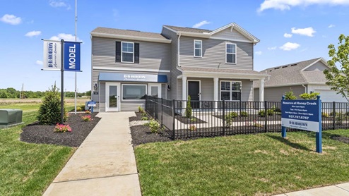 Front exterior of model home with gray siding.