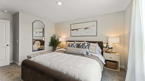 Staged bedroom with a queen sized bed.
