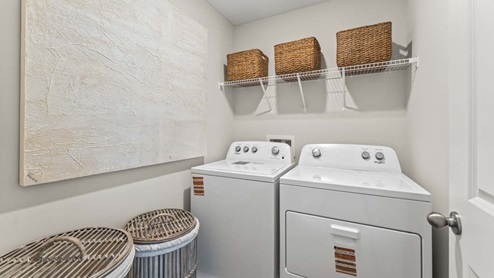 Laundry room with a built in storage shelf.