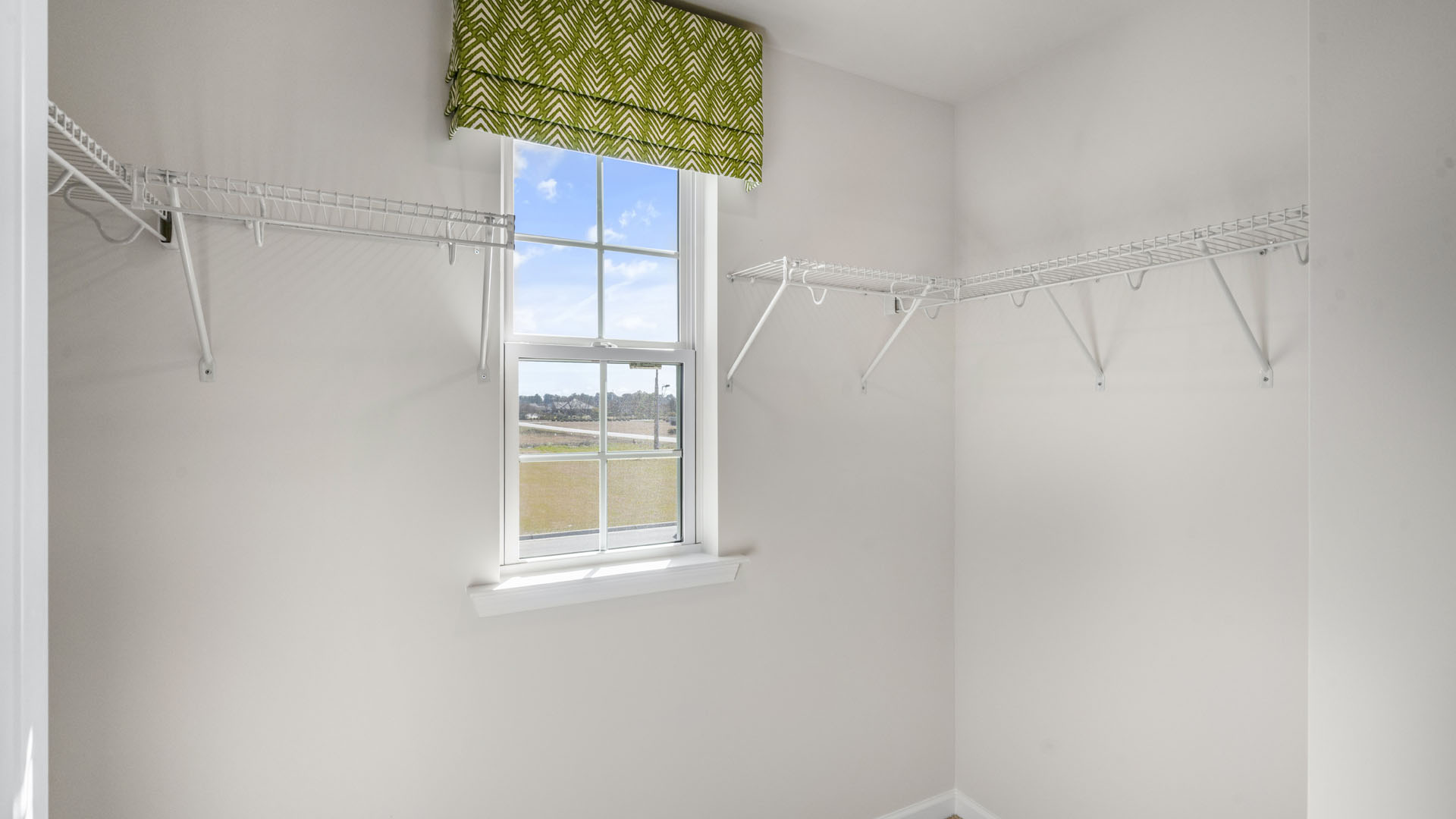 Walkin-Closet with small window and shelving.