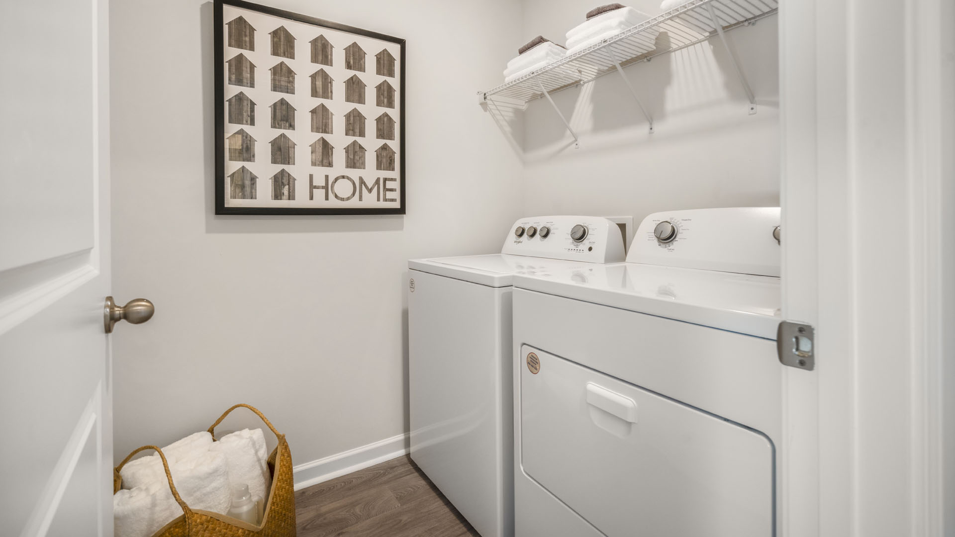 Laundry room with whirpool appliances, extra storage, and modern art.