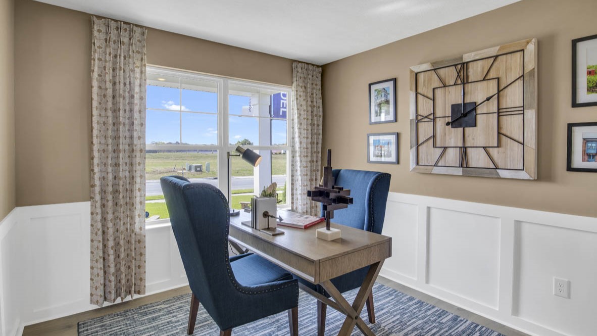 Flex room setup as an office space with blue chairs and clock centerpiece