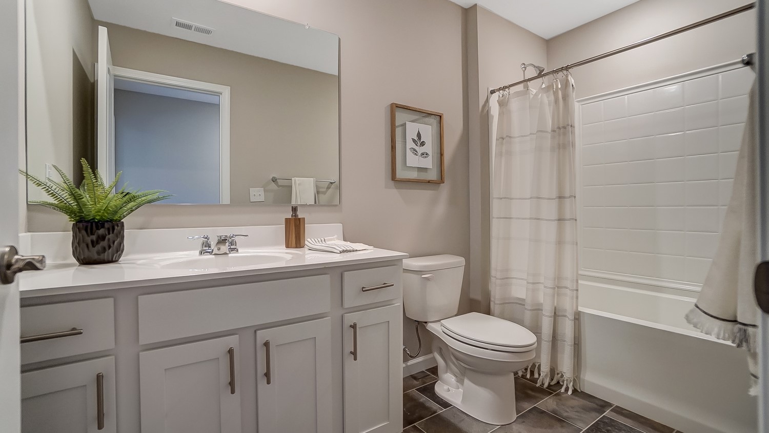 shared bathroom with white cabinets and shower and tub combo.