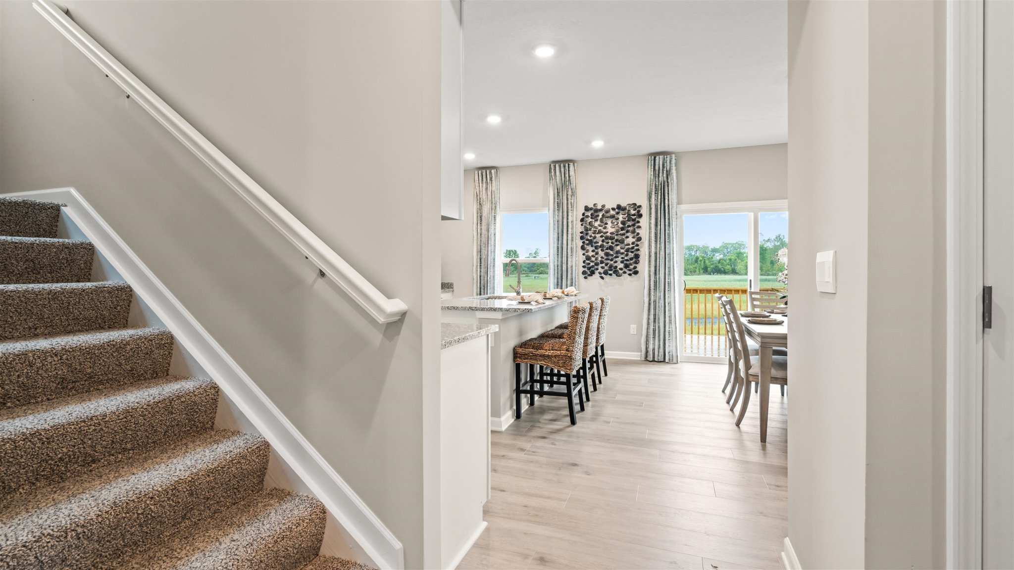 stairs going upstairs and view of kitchen and dining room.