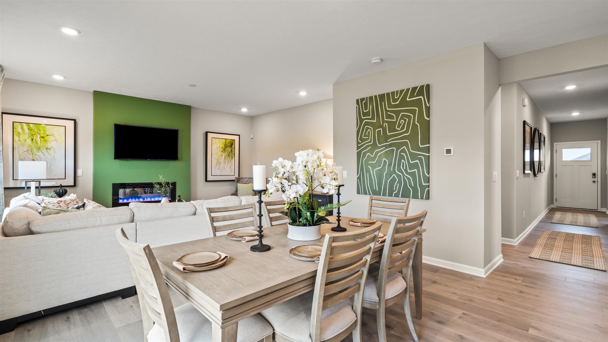 view of casual dining room overlooking the living room with the hallway to the front door in view.