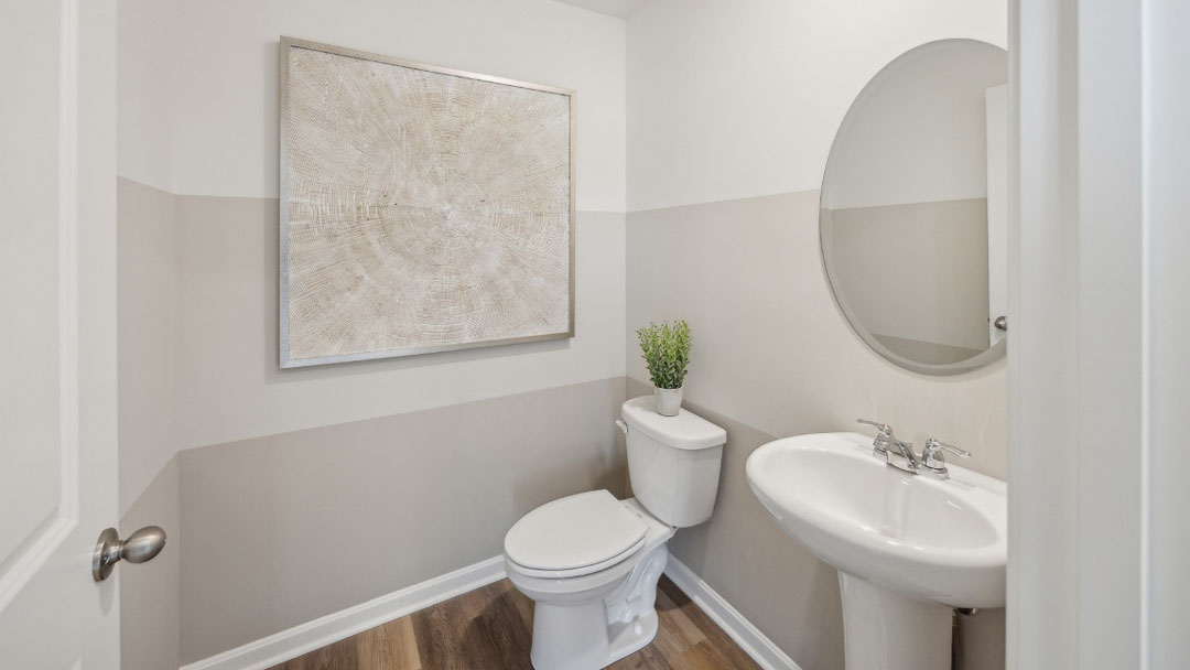 bathroom with a pedestal sink and mirror above and a toilet