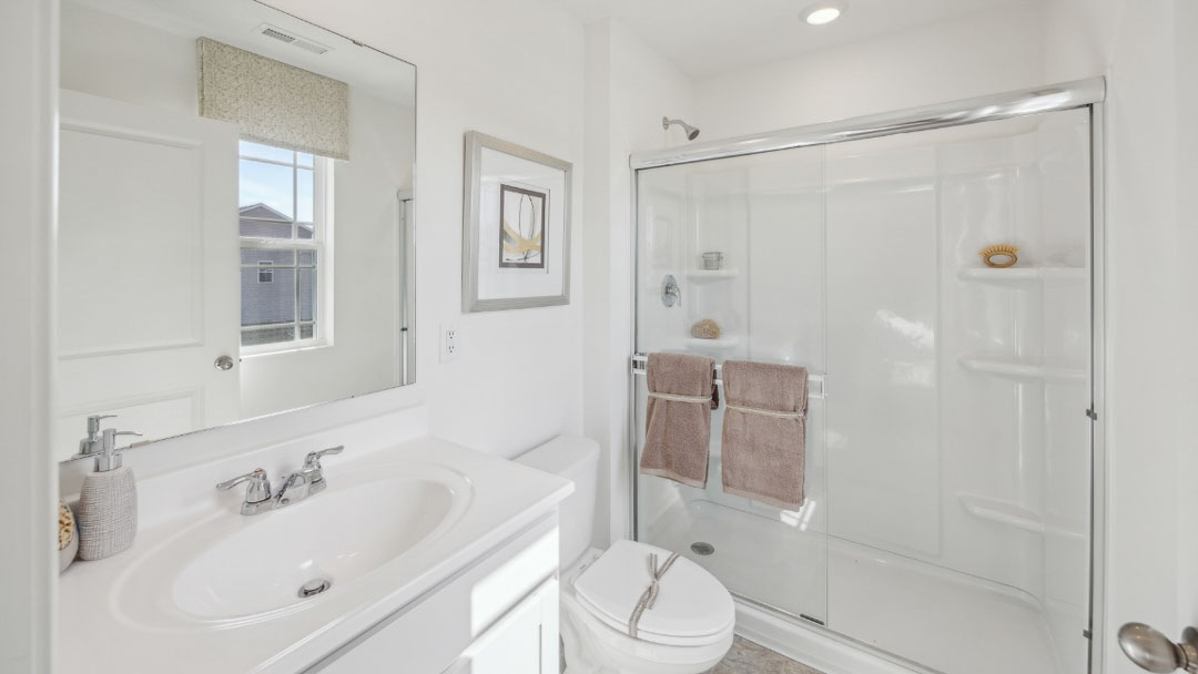 spacious bathroom featuring a vanity sink, toilet, and walk in shower