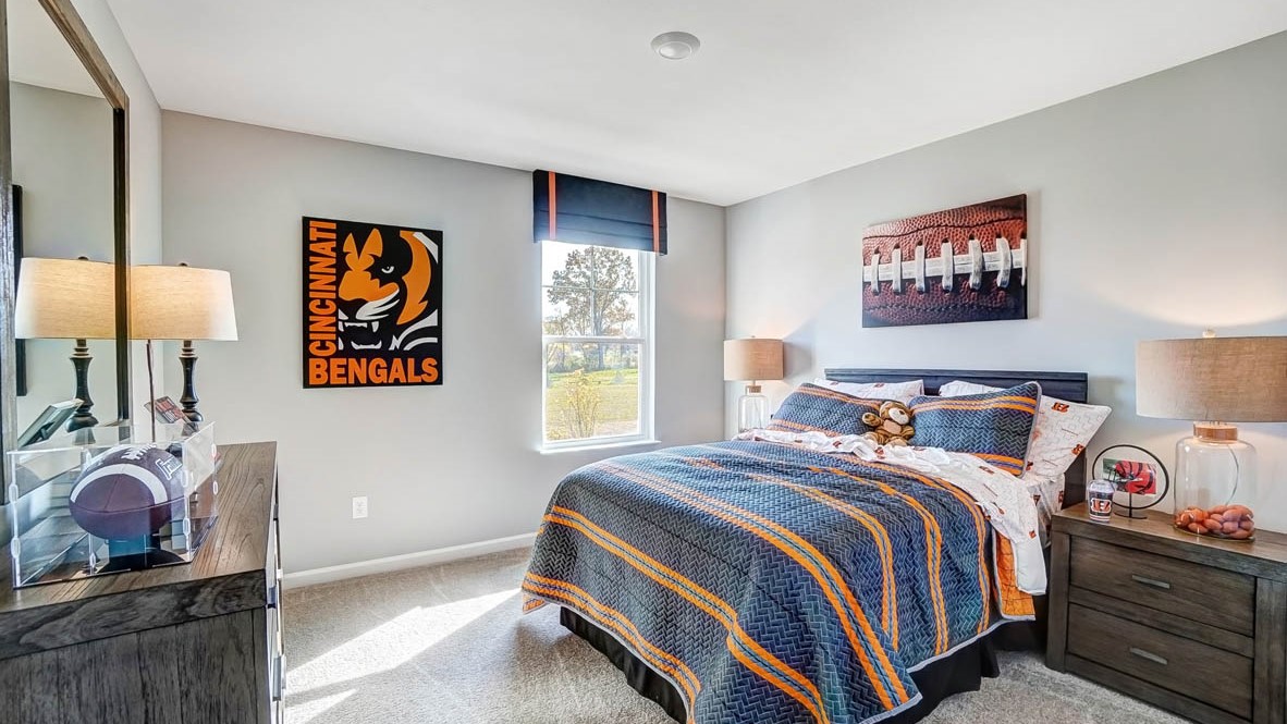 bengals themed room with large bed, bedside tables, and football art.