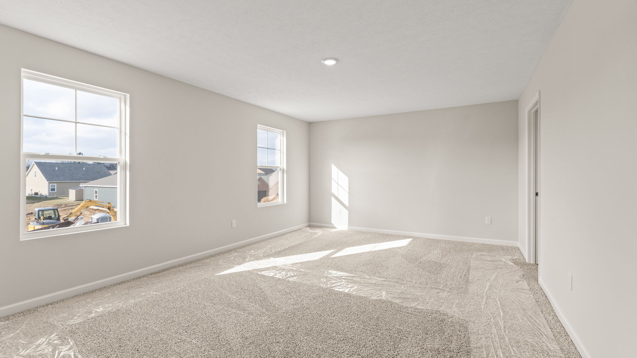Carpeted primary bedroom with two windows
