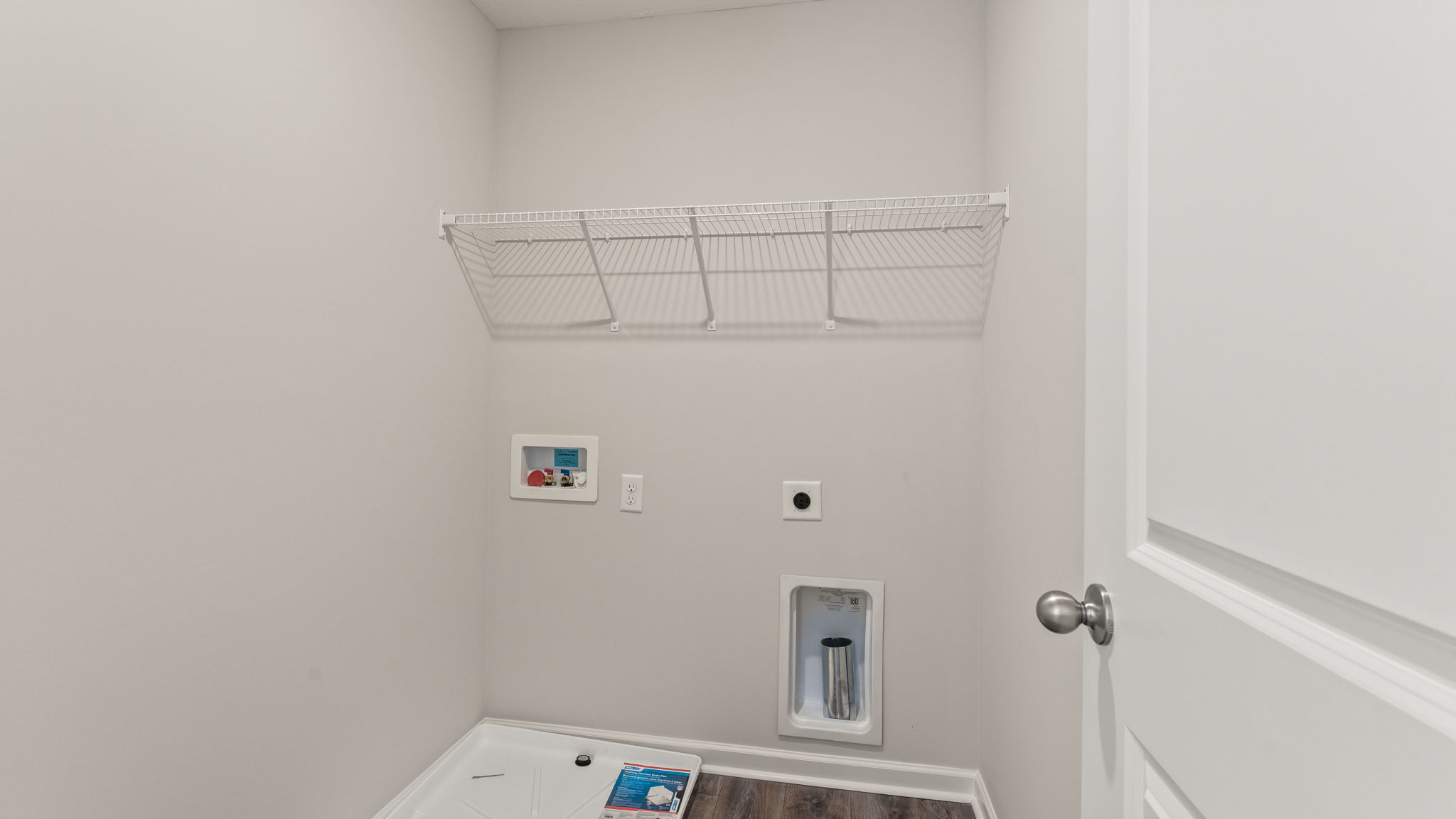 Laundry area with washer/dryer inlets and wire rack shelving