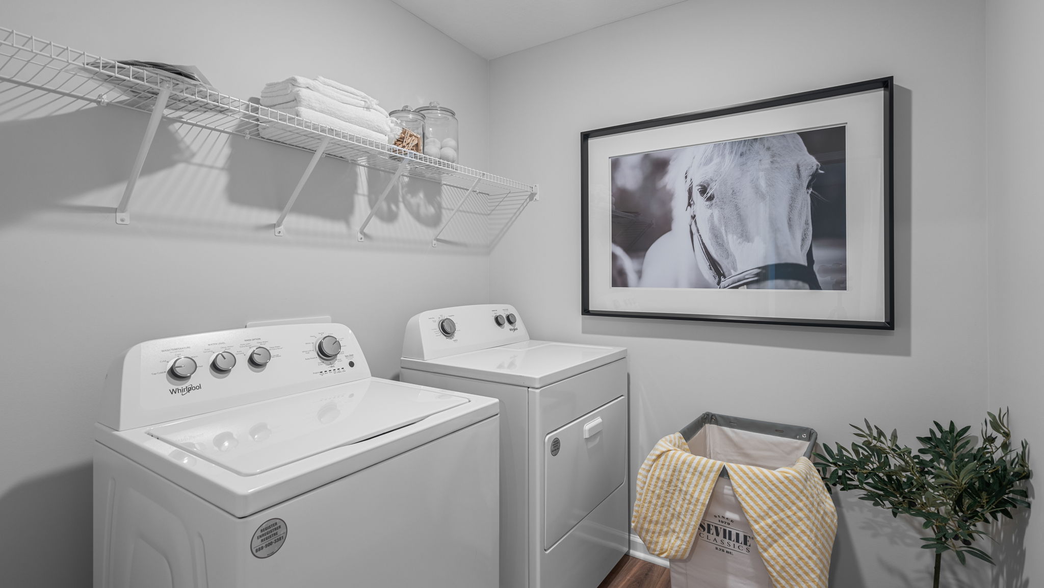 Laundry room with hanging storage racks. Backyard with wood deck.