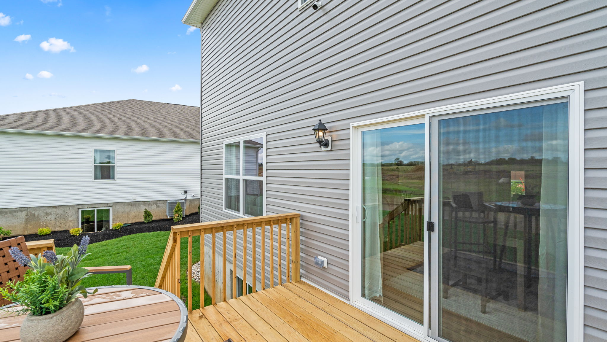 View of backyard with glass sliding doors to home.
