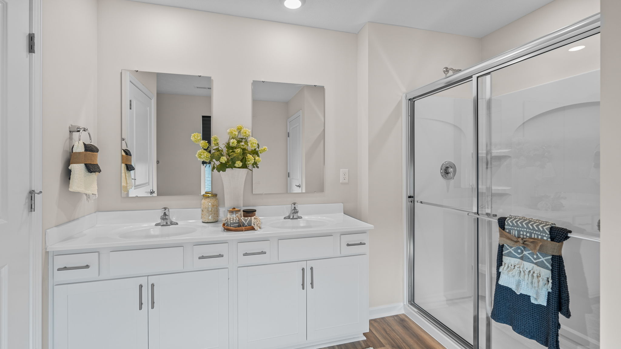 Primary bathroom with walk in shower with glass doors.