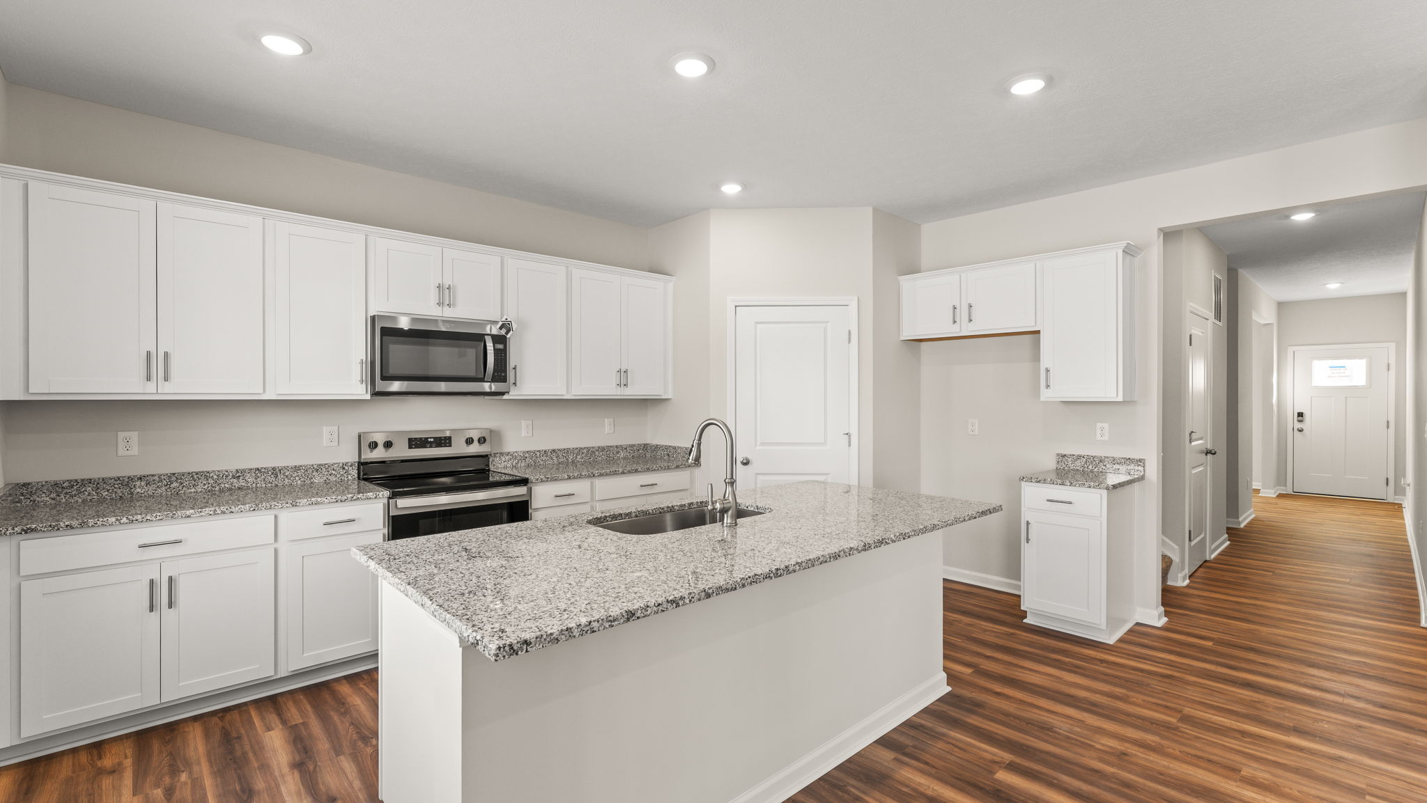 Full kitchen with island, appliances, and white cabinetry