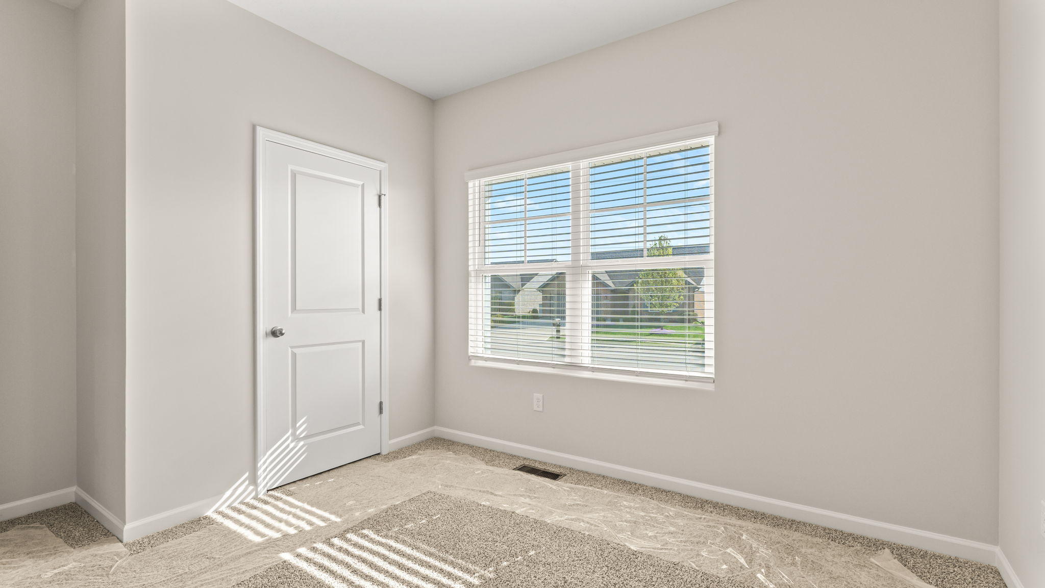 Carpeted bedroom with window and closet