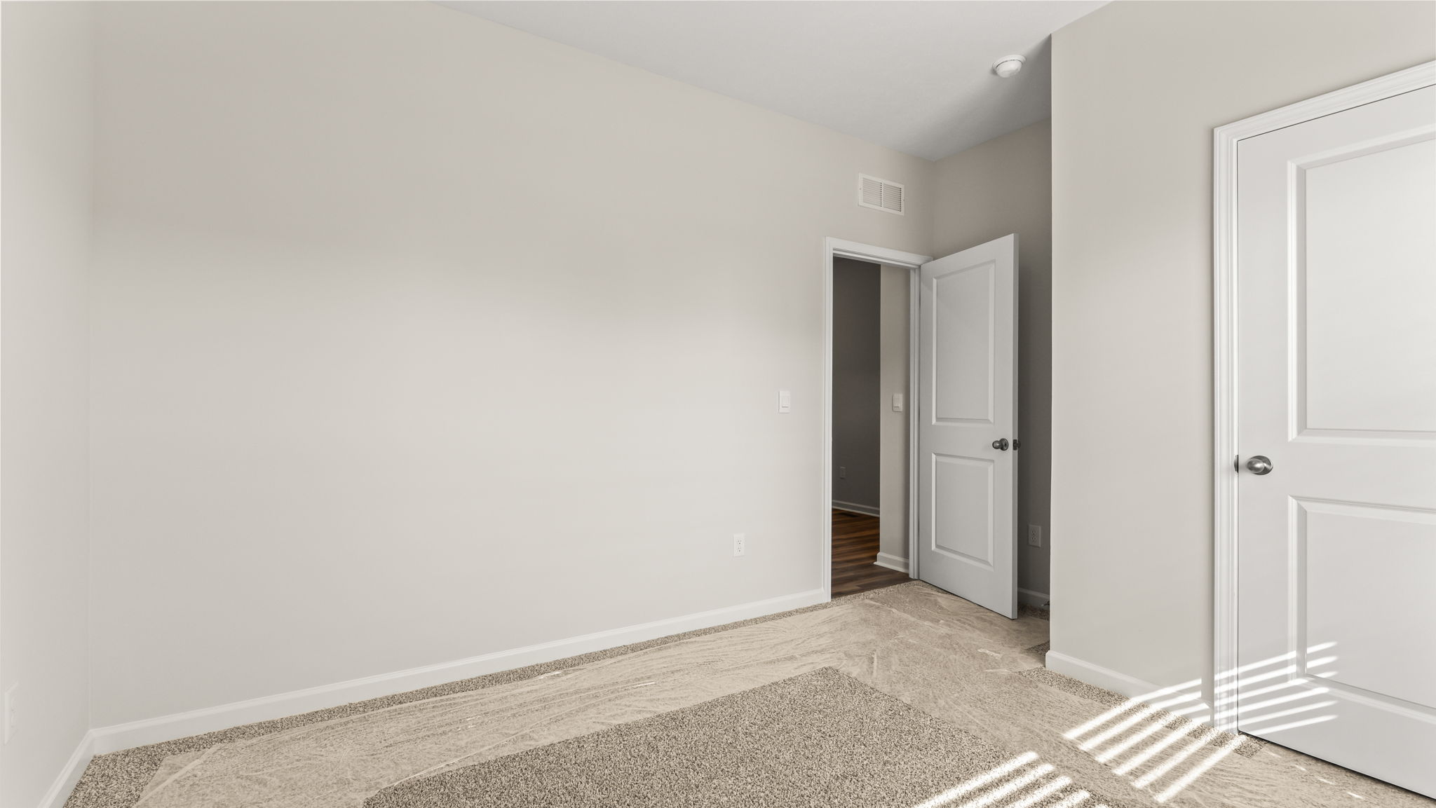 Carpeted bedroom with door to closet