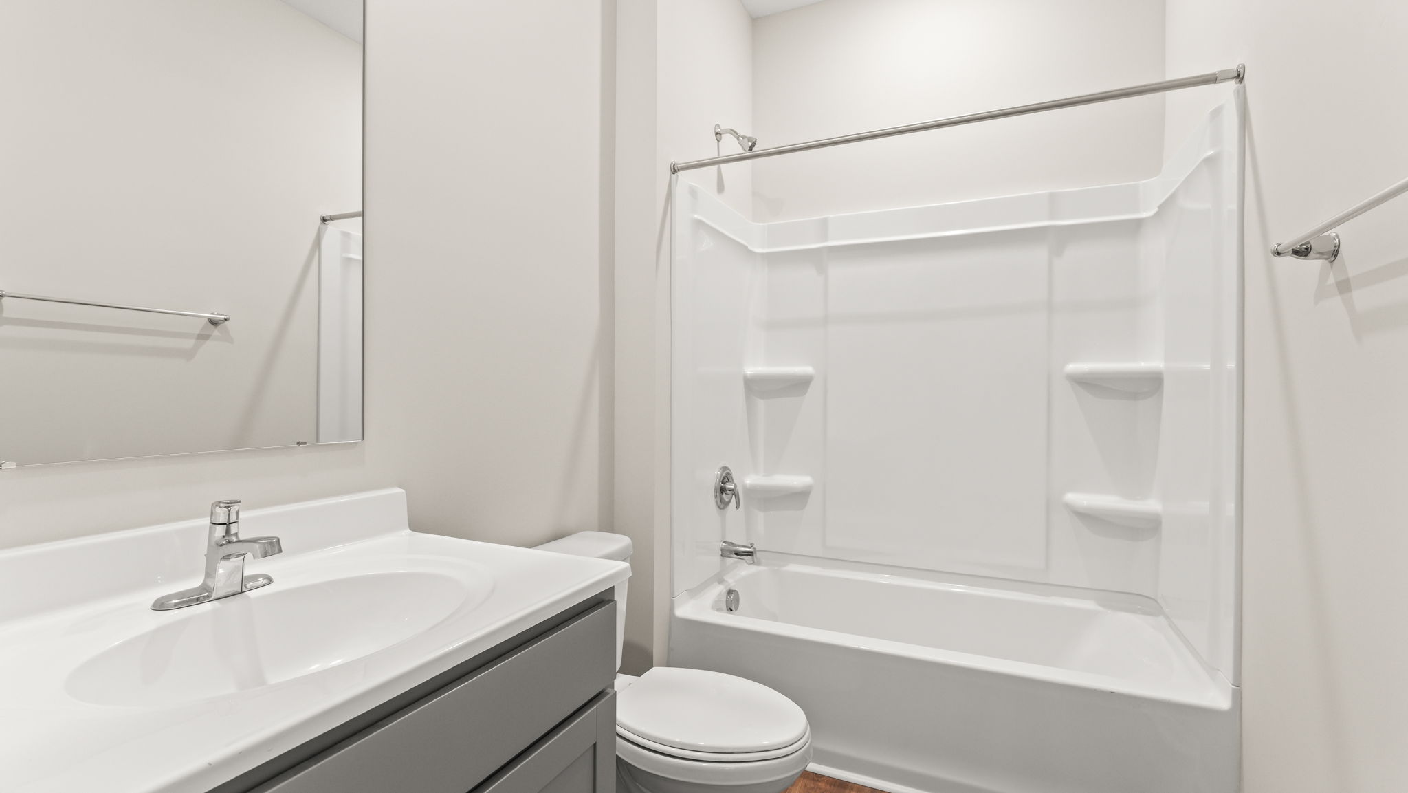 Bathroom with sink, mirror, toilet, and tub with tiered shelving